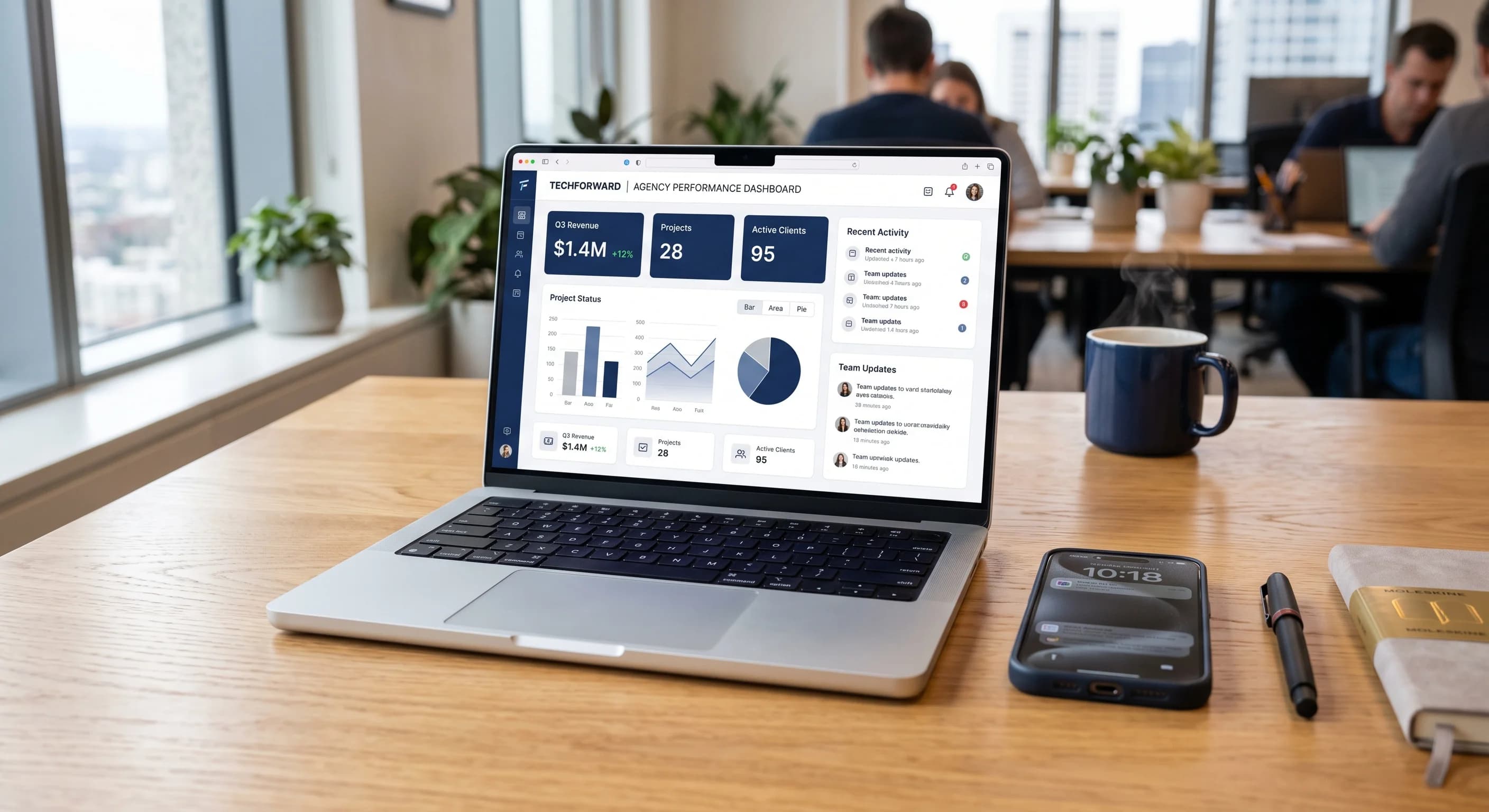 Laptop di atas meja kantor menampilkan dashboard laporan kinerja perusahaan, dengan ponsel dan buku catatan di sampingnya.